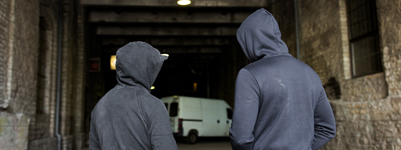 Two youth with hoodies shown from behind